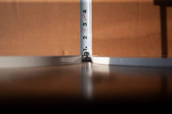 A measuring tape rests between a 1/2 inch thick and a 3/8 inch thick AR500 steel target